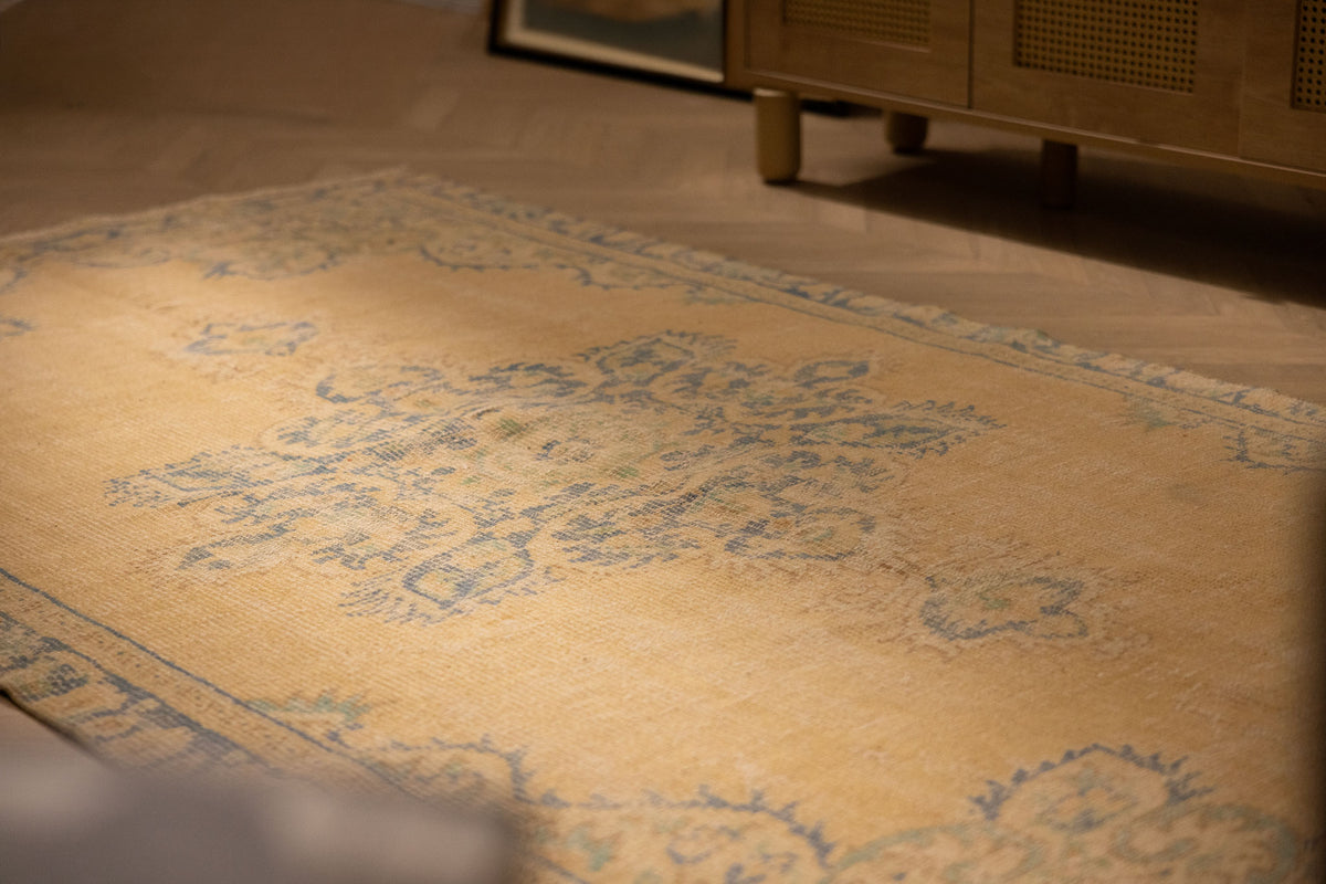 Hand-woven vintage Manisa Turkish rug in yellow and blue with traditional floral patterns, 4x8 ft wool and cotton blend.