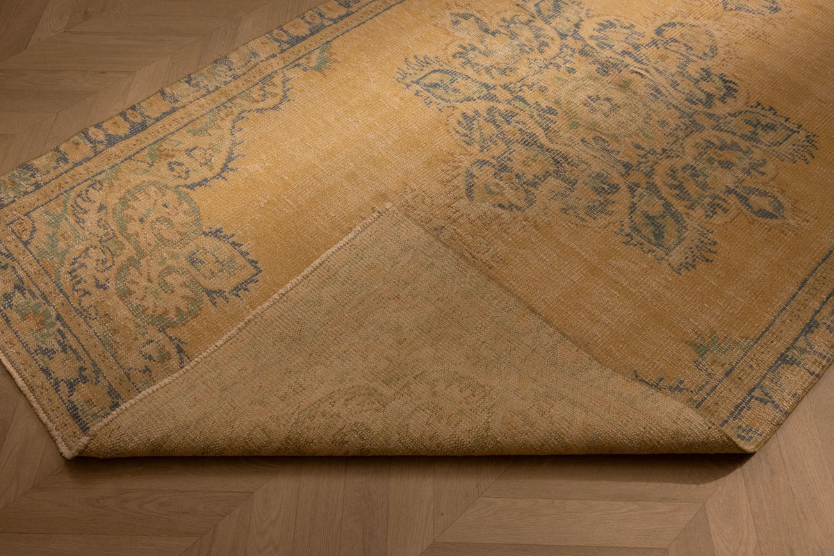 Hand-woven vintage Manisa Turkish rug in yellow and blue with floral patterns, 4x8 ft wool and cotton blend.