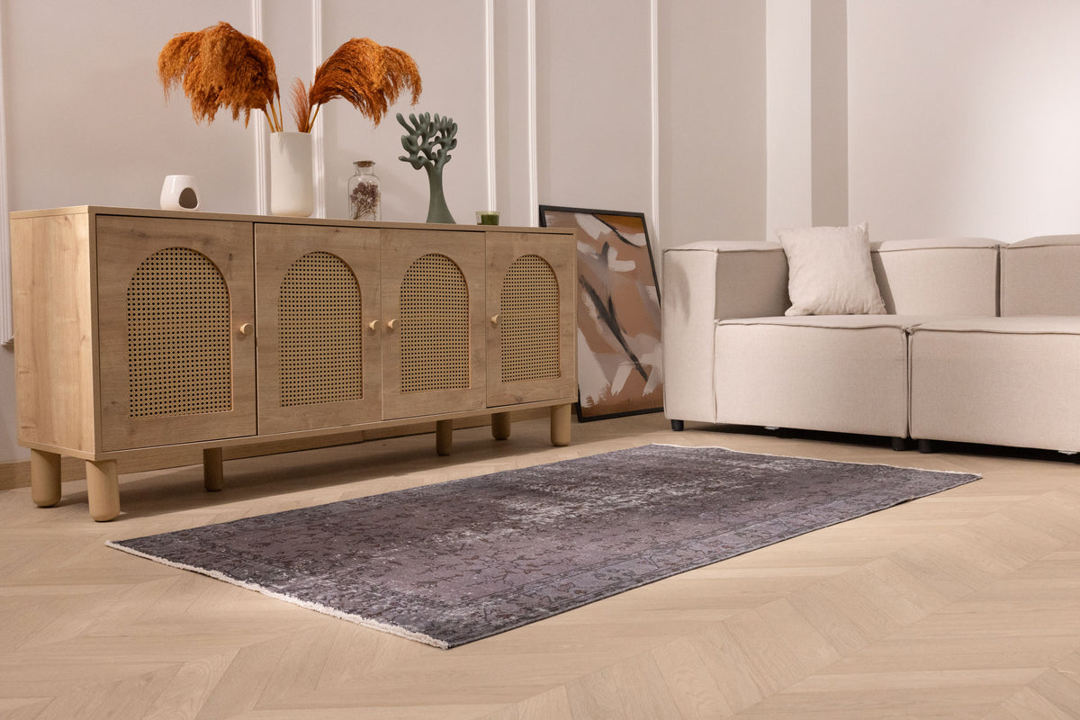 Hand-woven gray overdyed vintage Isparta wool and cotton area rug with floral motifs in a modern living room setting.
