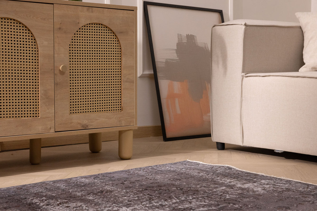 Hand-woven gray overdyed vintage Isparta Turkish wool and cotton area rug with floral motifs on a wooden floor.