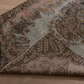Hand-woven vintage Isparta wool and cotton rug in brown and gray with maximalist floral patterns on a wooden floor.