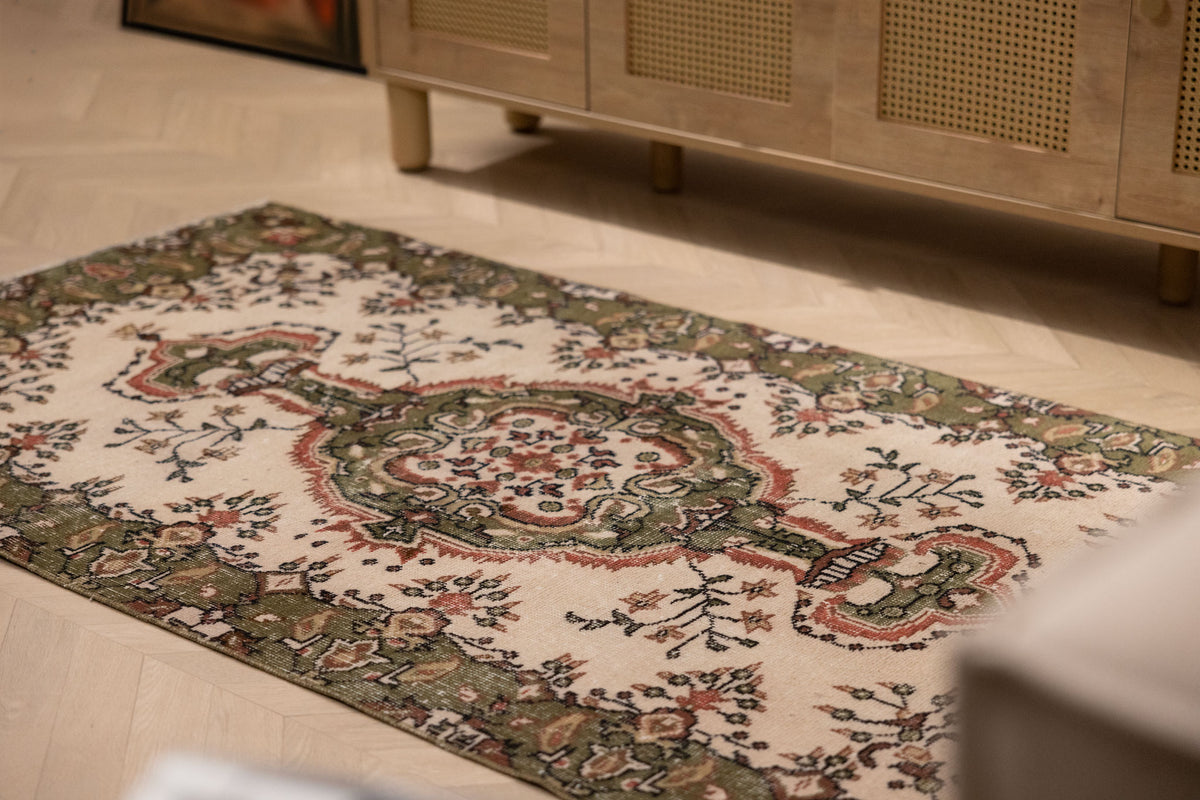 Hand-woven vintage Isparta rug in white and sage green with intricate floral patterns and maximalist bohemian style.