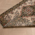 Hand-woven vintage Isparta rug in white and sage green with floral maximalist patterns, 3.5x6.6 ft wool and cotton blend.