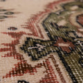 Hand-woven vintage Isparta rug in white and sage green with intricate floral patterns and a soft wool-cotton blend texture.