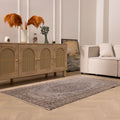 Vintage gray overdyed Isparta Turkish wool and cotton rug with floral patterns in a modern living room setting.