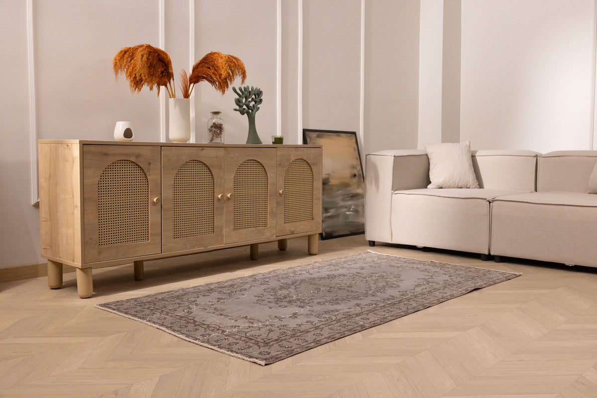 Vintage gray overdyed Isparta Turkish wool and cotton rug with floral patterns in a modern living room setting.
