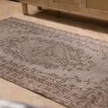 Hand-woven vintage gray overdyed Isparta Turkish wool and cotton rug with intricate floral patterns on a wooden floor.