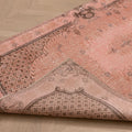Vintage 3x6 ft pink overdyed Turkish Isparta rug with floral patterns, hand-woven from wool and cotton on a wooden floor.