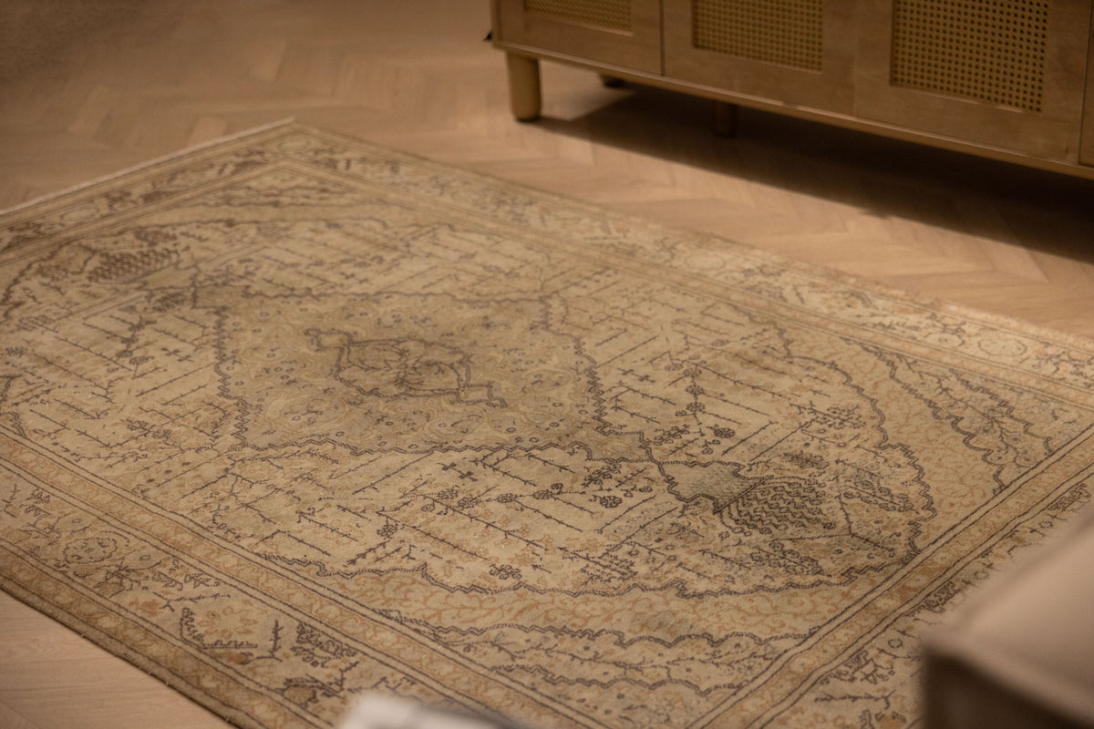 Hand-woven vintage Kayseri rug in gray and brown with intricate floral patterns on a wooden floor.