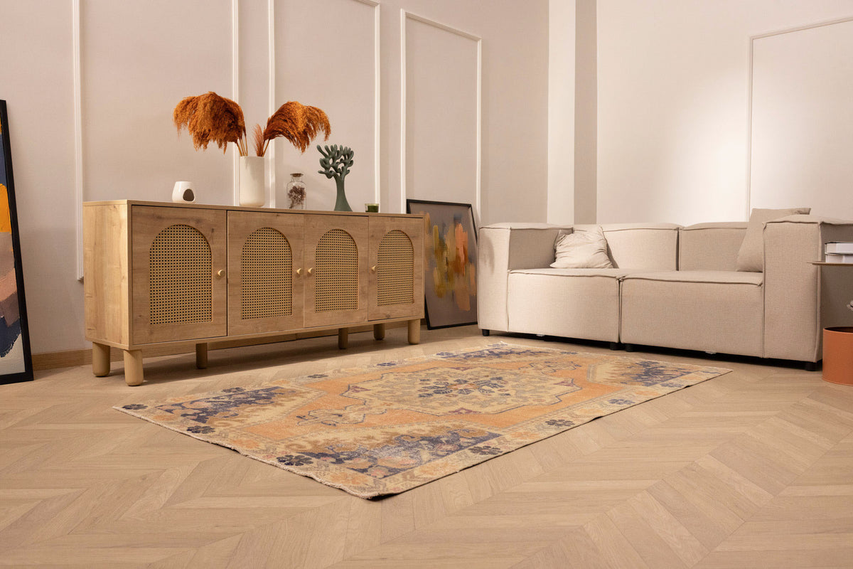 Hand-woven 4x7 ft vintage Turkish rug in orange and beige with a floral medallion design in a modern living room.