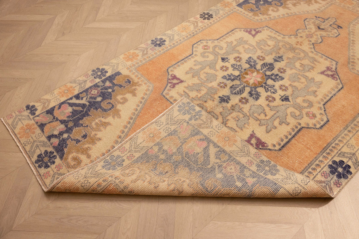 Hand-woven vintage Turkish rug in orange and beige with a floral medallion pattern, 4x7 ft wool and cotton blend.