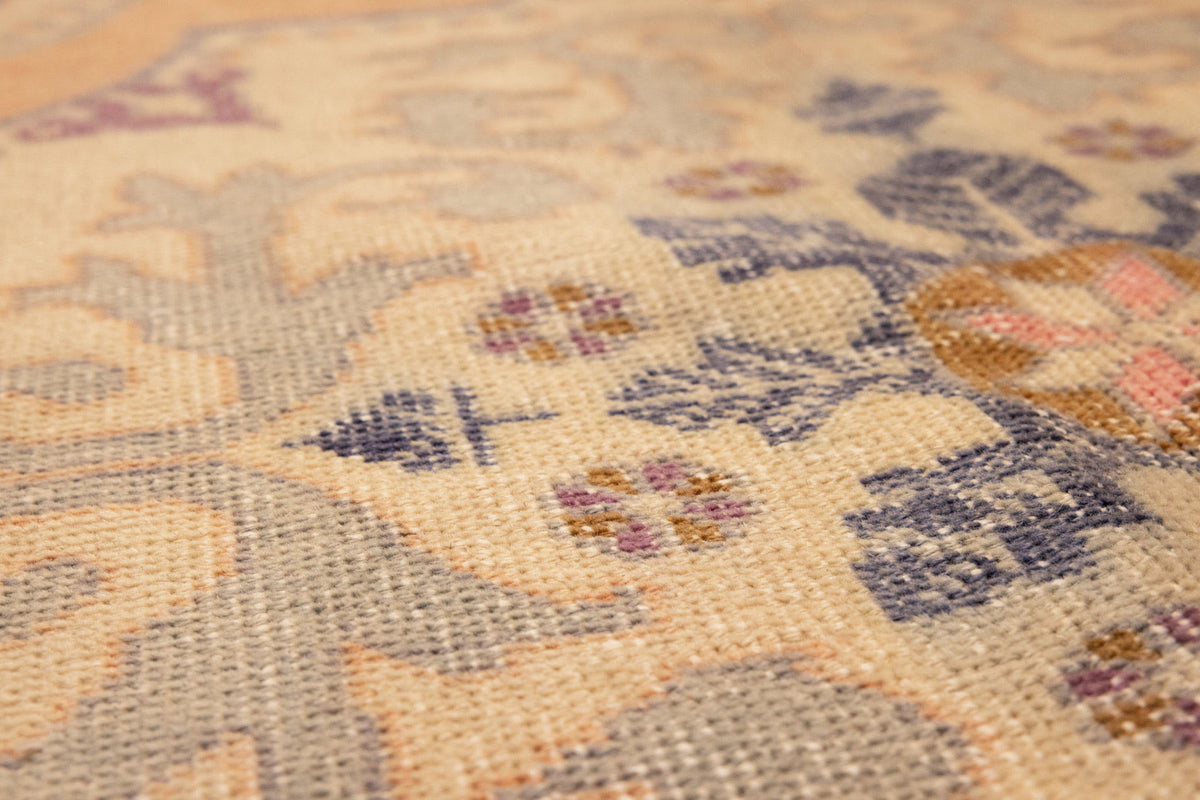 Hand-woven vintage Turkish rug in orange and beige with intricate floral medallion patterns and low-pile wool-cotton texture.