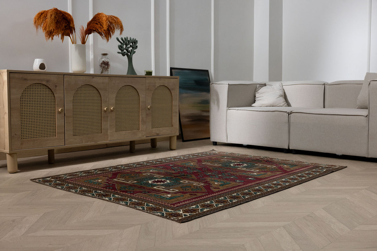 Hand-woven 4x6 ft vintage Kars wool rug with red and brown geometric patterns in a modern living room setting.