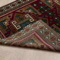 Hand-woven 4x6 ft vintage Turkish wool rug in red and brown with intricate geometric patterns and a folded corner.