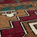 Hand-woven vintage Kars wool rug with red, brown, and teal geometric patterns in a low-pile bohemian style.