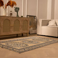 Hand-woven 3x6 ft vintage Oushak wool rug in beige and navy with geometric patterns in a modern bohemian living room.