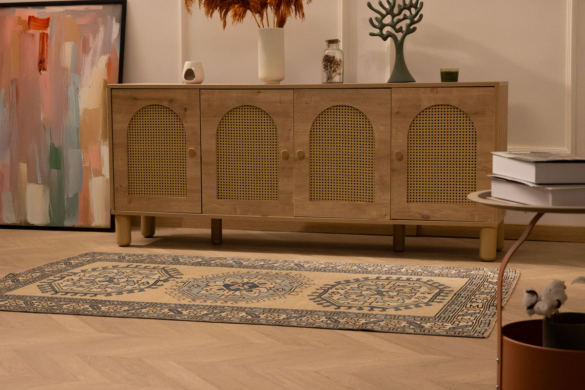 Hand-woven 3x6 ft vintage Oushak wool rug in beige and navy with geometric patterns on a wooden floor.