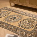 Hand-woven 3x6 ft vintage Oushak wool rug in beige and navy with traditional geometric patterns on a wooden floor.