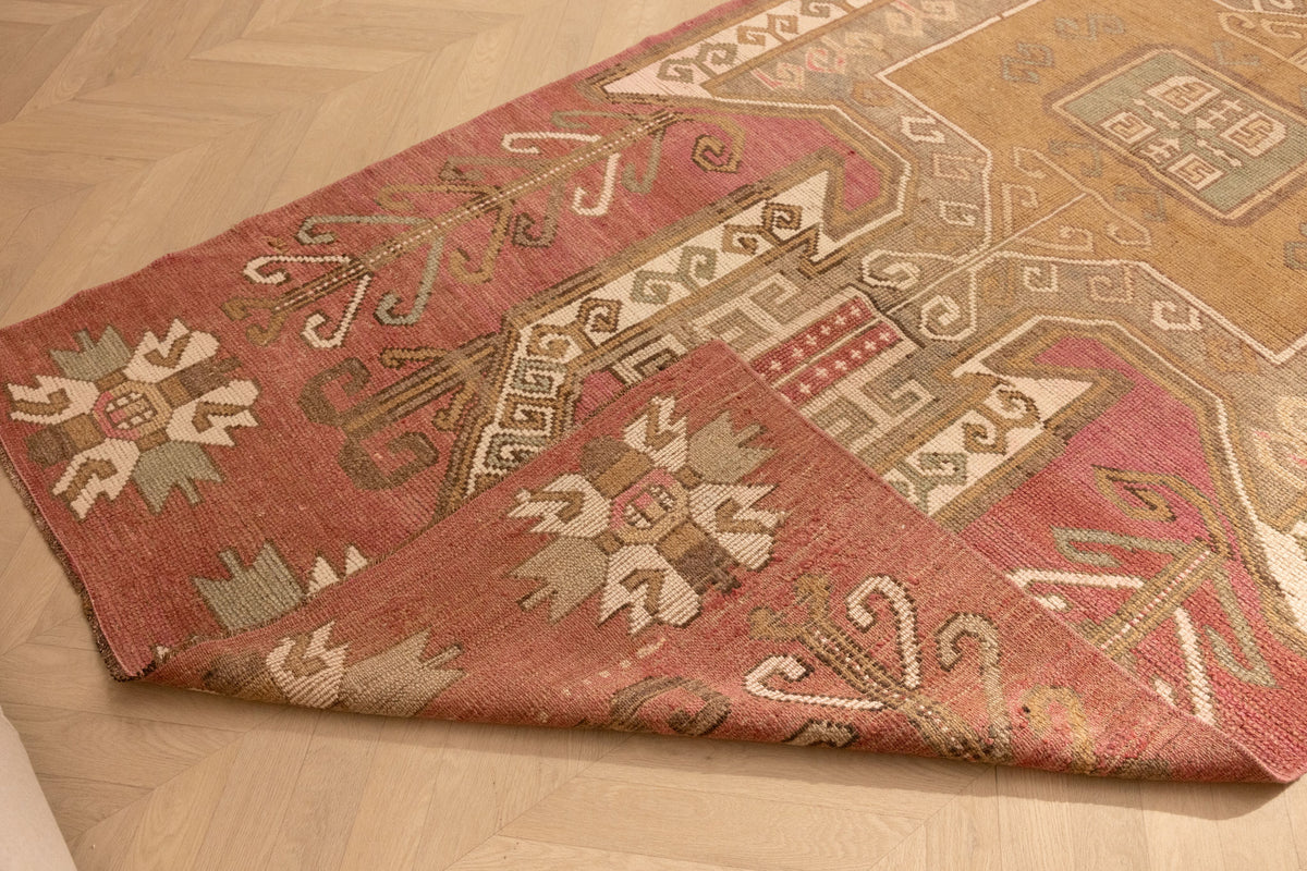 Hand-woven vintage Turkish runner rug in red and pink with geometric patterns, crafted from wool and cotton.