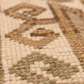 Close-up of a hand-woven vintage Turkish wool runner rug featuring detailed geometric patterns in earthy tones.