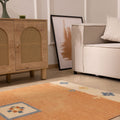Hand-woven 3x5 ft vintage Turkish area rug in orange and beige with geometric patterns in a minimalist living room.