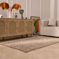 Hand-woven 1x3 ft vintage Isparta rug in beige and brown with intricate floral patterns on a wooden floor.