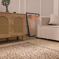 Hand-woven 1x3 ft vintage Isparta rug in beige and brown with intricate floral patterns on a wooden floor.