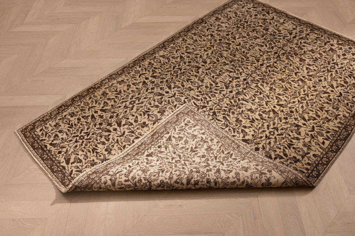 Hand-woven 1x3 ft vintage Isparta wool and cotton rug in beige and brown with intricate maximalist floral patterns.