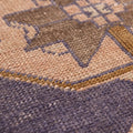 Close-up of a vintage Turkish wool and cotton runner rug featuring orange and navy geometric tribal patterns.