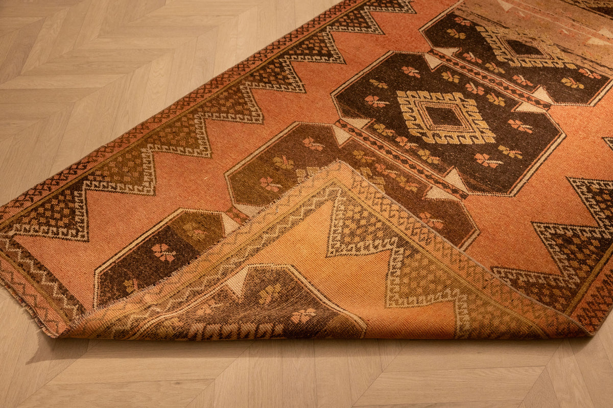 Vintage 4x11 ft Turkish runner rug in orange and brown with geometric patterns, handwoven from wool and cotton.
