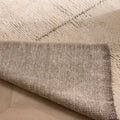 Handwoven brown and cream shaggy wool rug with a thick, textured pile and durable cotton backing on a wooden floor.