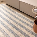 Handwoven white and blue striped wool-cotton flatweave rug in a modern living room setting.
