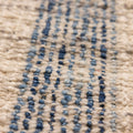 Close-up of a handwoven white and blue striped wool-cotton flatweave rug with a textured, durable finish.