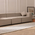 White and blue striped flatweave rug with fringed edges, crafted from wool and cotton in a modern living room setting.