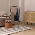White and blue striped wool-blend flatweave rug with decorative fringe in a modern living room setting.