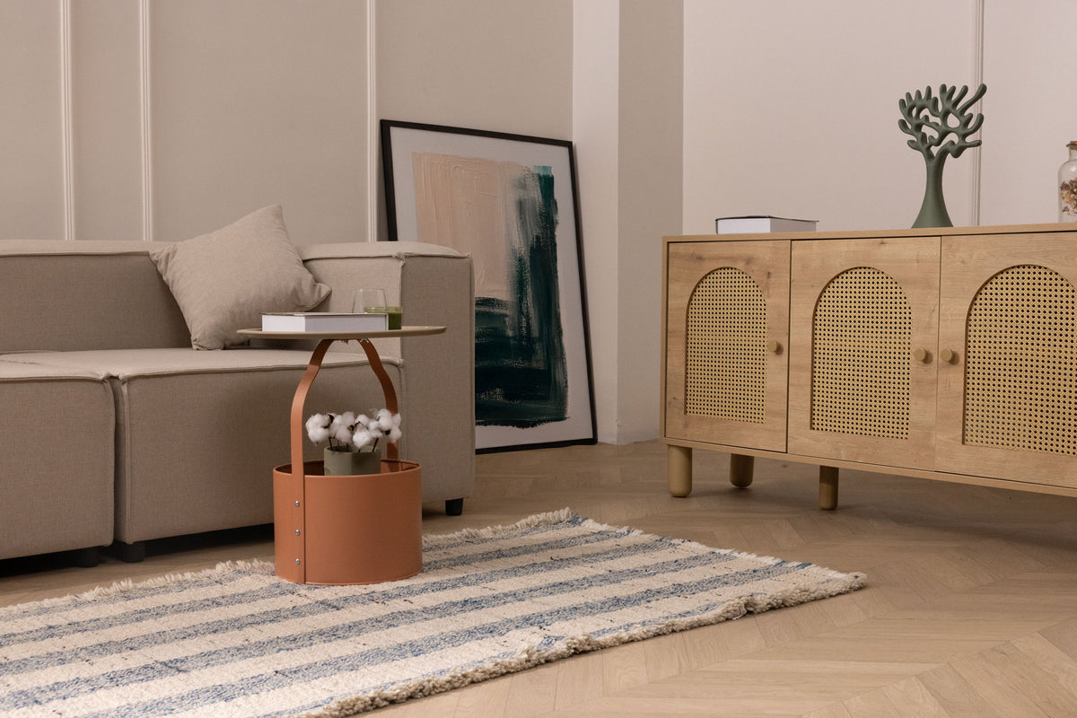 White and blue striped wool-blend flatweave rug with decorative fringe in a modern living room setting.