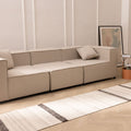 Handwoven white and black wool-blend flatweave runner rug on a light wood herringbone floor in a modern living room.