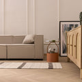 Handwoven black and white wool-blend flatweave rug with striped pattern in a modern living room setting.