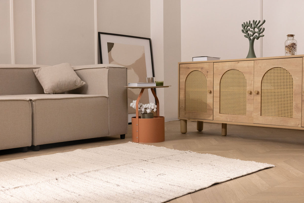 Minimalist white wool and cotton flatweave rug in a modern living room with neutral decor and herringbone flooring.