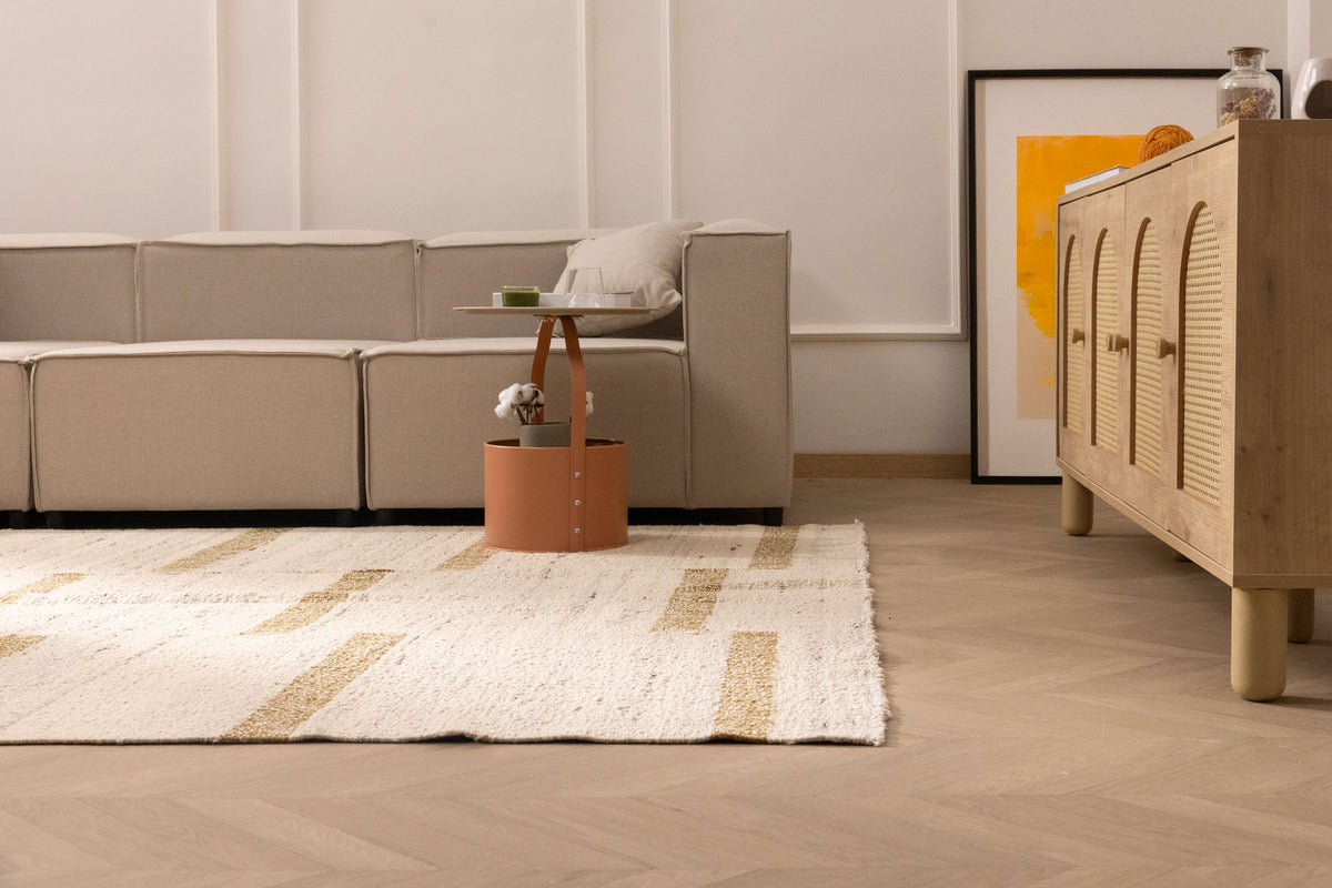 Handwoven white and brown wool-cotton flatweave rug with a geometric pattern in a modern living room.