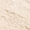 Close-up of a white and brown handwoven wool-blend flatweave rug with a textured, durable, and eco-friendly design.