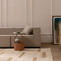 Beige and brown handwoven wool-blend flatweave rug with a geometric pattern in a modern living room setting.