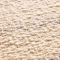 Close-up of a white handwoven wool and cotton flatweave rug with a textured, durable surface.