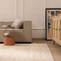 Minimalist white handwoven wool and cotton flatweave rug in a modern living room setting.