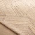 Handwoven white wool and cotton flatweave rug with a textured striped pattern and a folded corner on wood flooring.