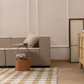 Handwoven white, brown, and blue checkered wool-blend flatweave rug in a modern, minimalist living room setting.