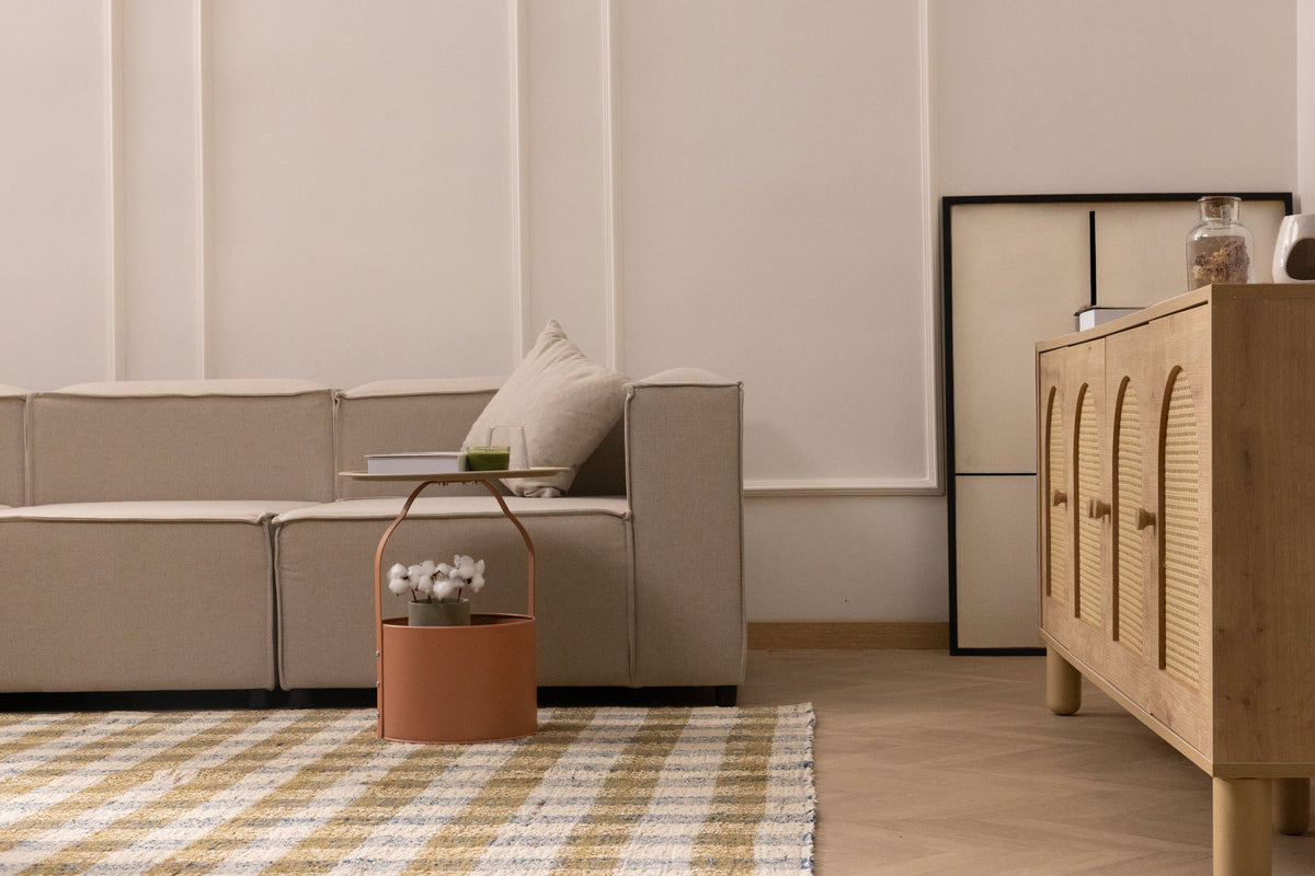 Handwoven white, brown, and blue checkered wool-blend flatweave rug in a modern, minimalist living room setting.