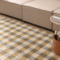 Handwoven white, brown, and blue checkered wool-blend flatweave rug in a modern living room setting.
