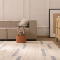 Handwoven white and blue wool-blend flatweave rug with a minimalist geometric pattern in a modern living room.