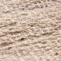 Close-up of a handwoven white and blue wool-blend flatweave rug with a textured, durable, and eco-friendly design.